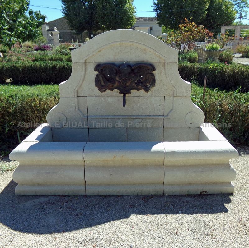Fontaine murale en pierre d'Avy avec ancienne plaque en fonte décorative