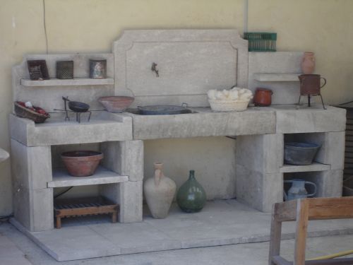Cuisine d'été avec évier en pierre produite par les ateliers de taille de pierre Bidal.