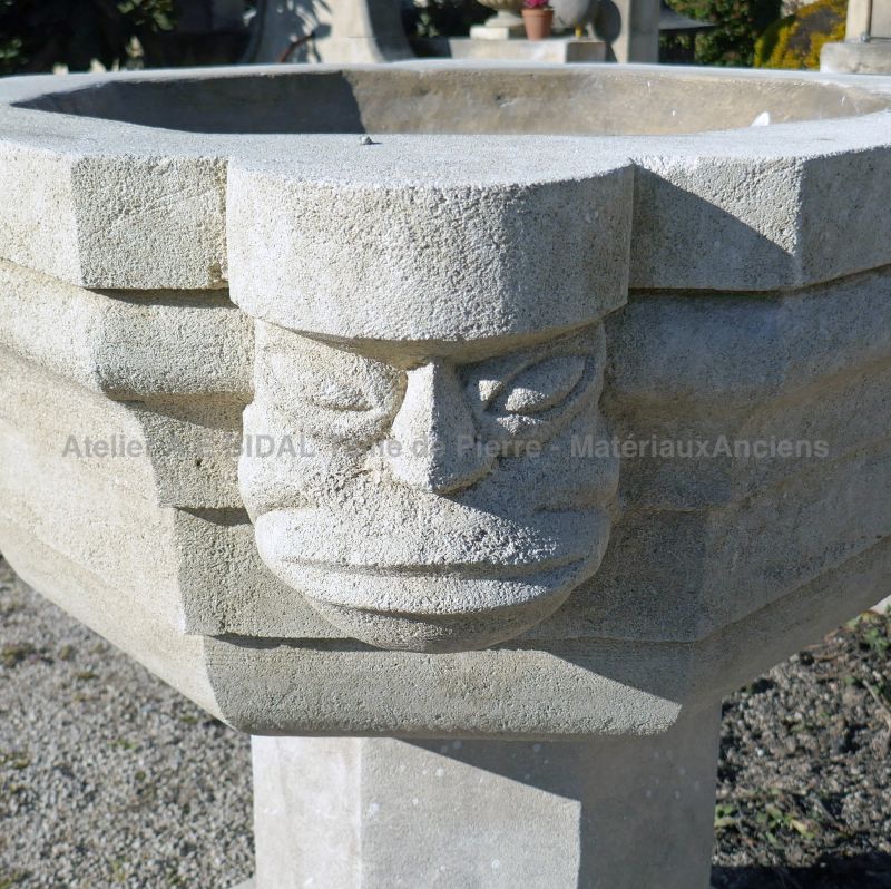 Tête sculptée à la main sur ce bénitier en pierre de Provence en vente chez Alain BIDAL