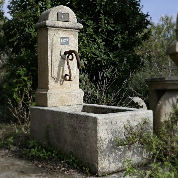 Fontaine provençale à bac massif du style borne à eau pour l'extérieur | Fontaine murale du tailleur de pierre Alain Bidal.