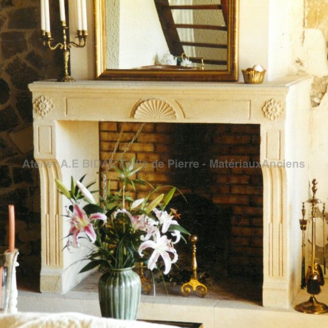 Louis XVI mantelpiece in stone - A classic stone fireplace crafted by a master stone cutter in Provence.