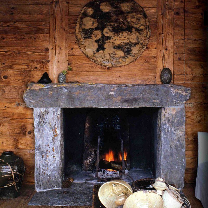 Charming rustic-looking fireplace in natural stone - Atelier Alain BIDAL (Provence)