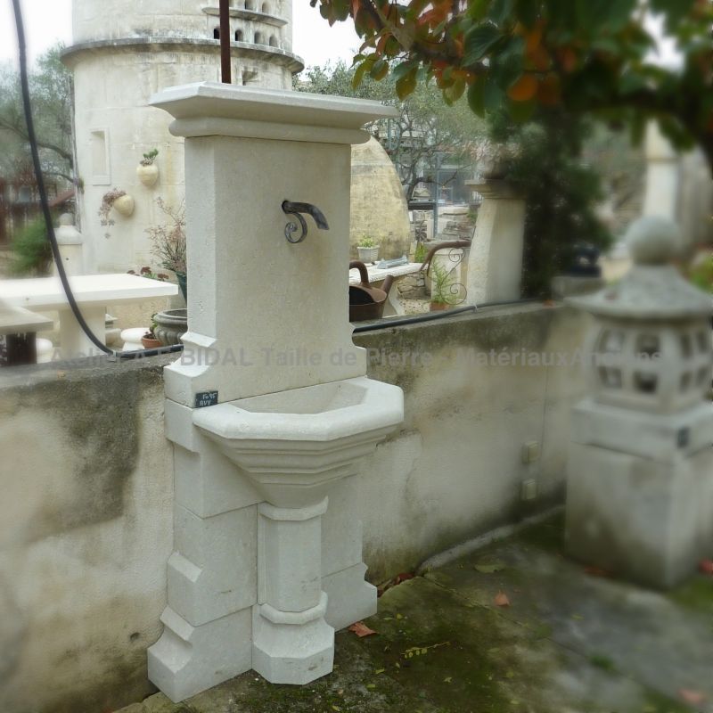 Rustic wall fountain in natural stone crafted by the stone mason Alain Bidal in Isle sur sorgue.