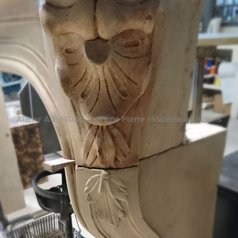 Handcrafted in stone, this Regence style fireplace is signed by Alain Bidal, stone cutter.