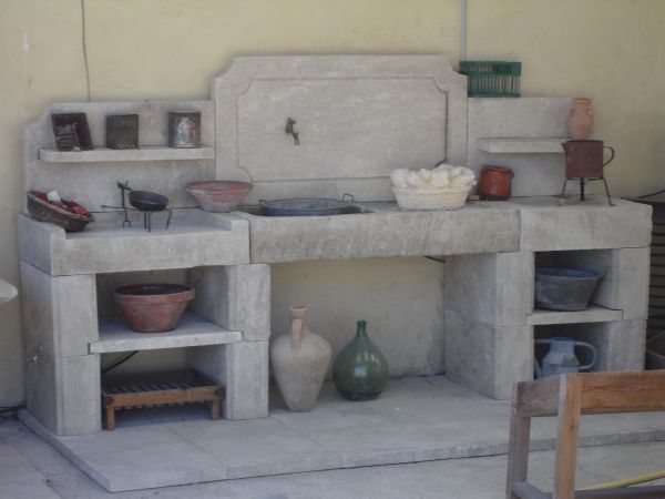 Cuisine d'été avec évier en pierre produite par les ateliers de taille de pierre Bidal.