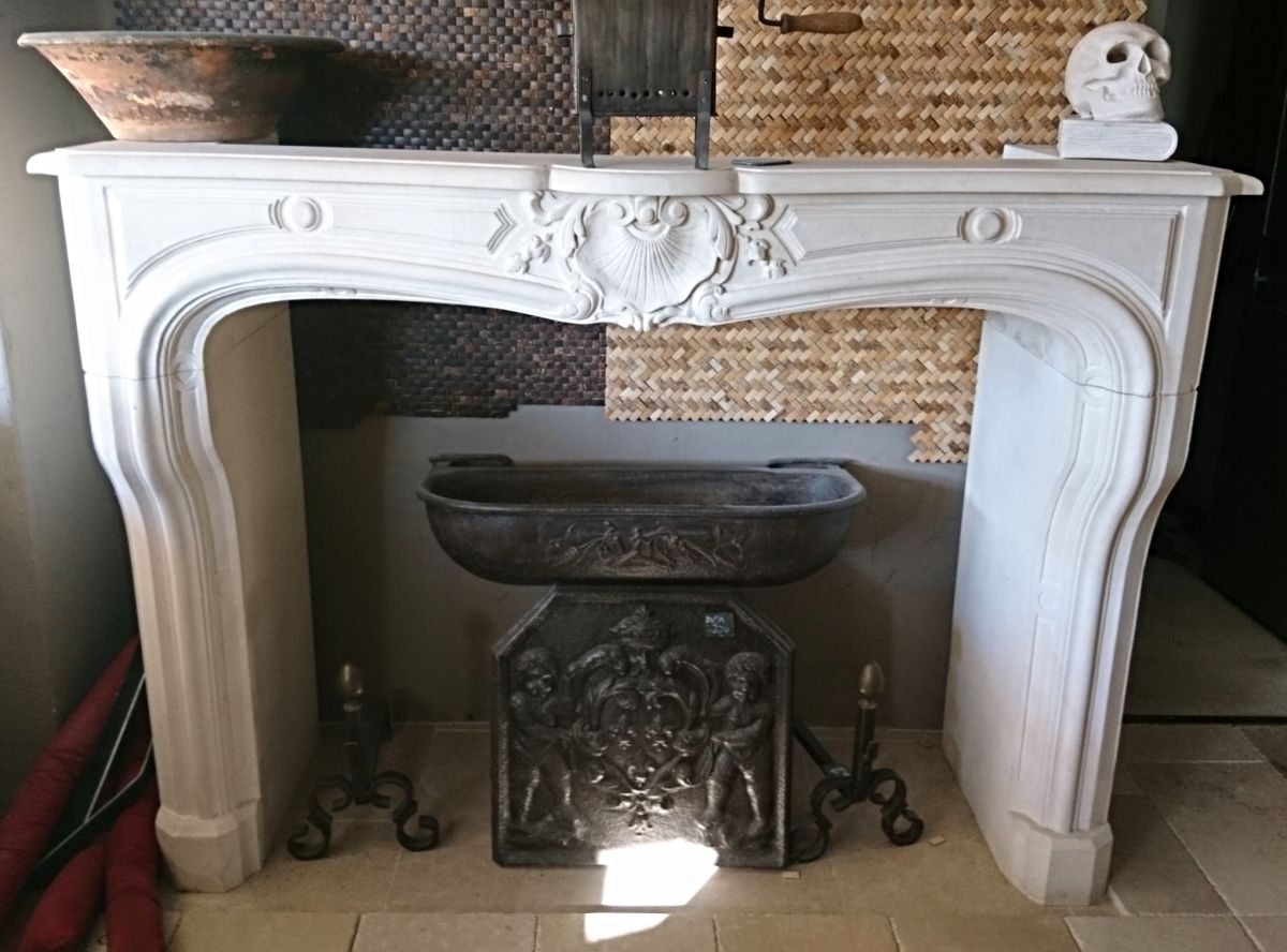 Beautiful fireplace in natural stone, a classic French Regency mantel