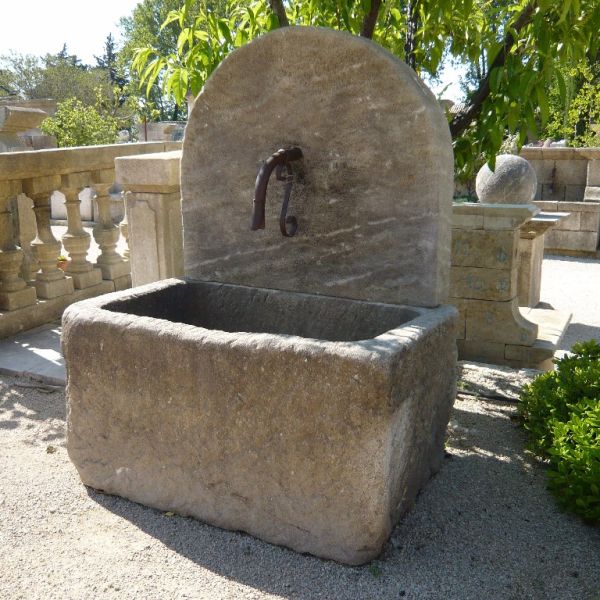 Garden wall fountain with massive trough by the stone cutting workshop Alain Bidal in Provence.