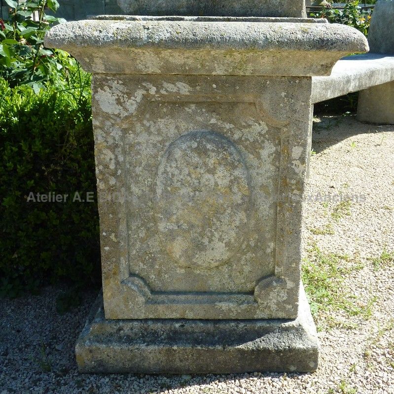 Pedestal crafted in natural stone for outdoor decoration.