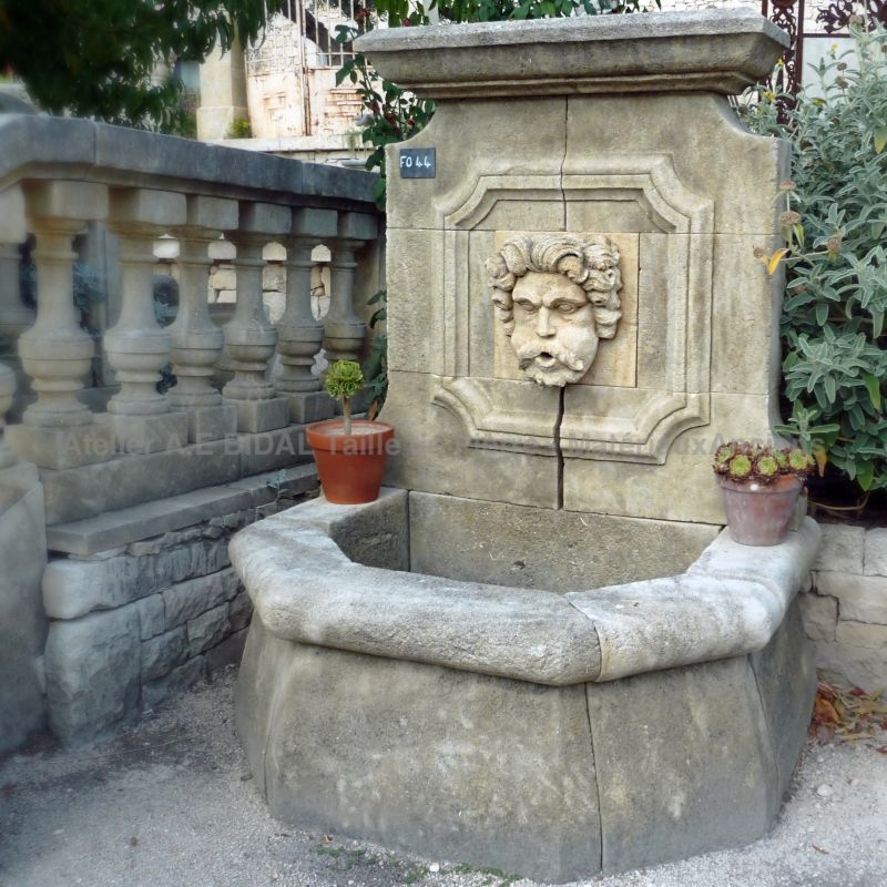 Fontaine rustique avec sculpture en pierre représentant le portrait d'Eole - Atelier Alain BIDAL (Provence)