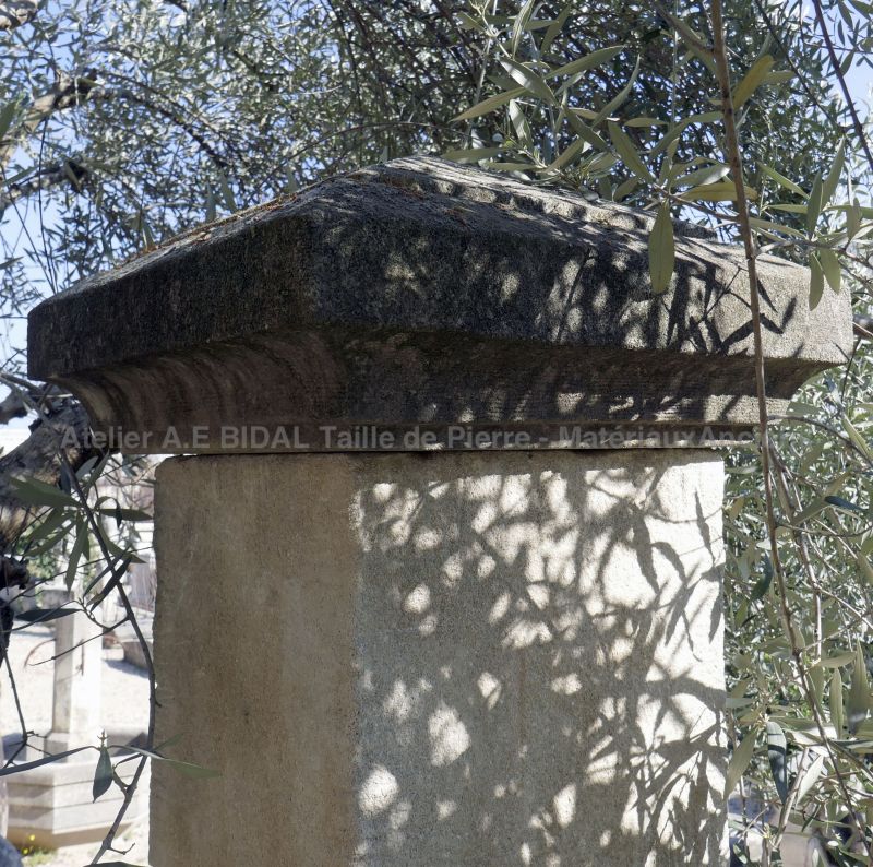 Pair of gate pillars with wheel-protectors and capital in a diamond peak shape carved in natural stone