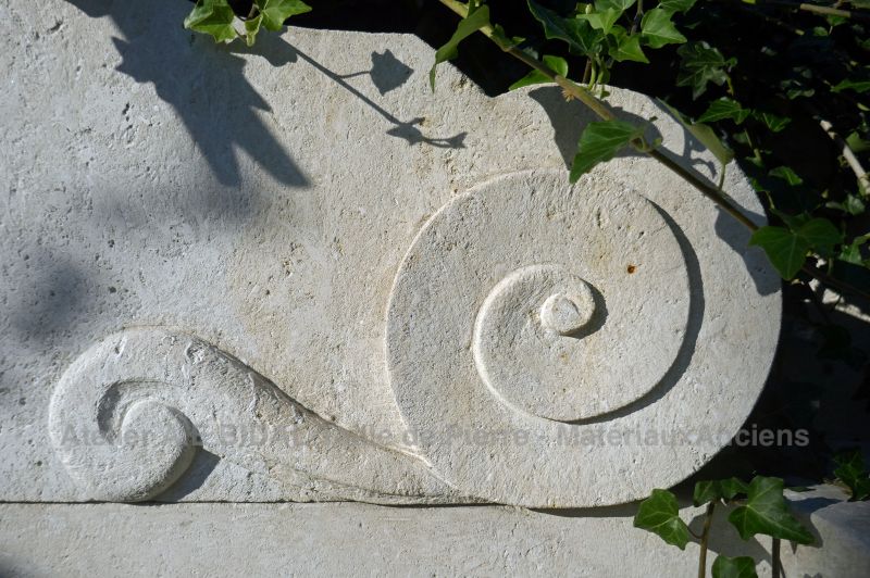 Detailed picture of the hand sculpted volute on the pediment of our wall fountain in stone.