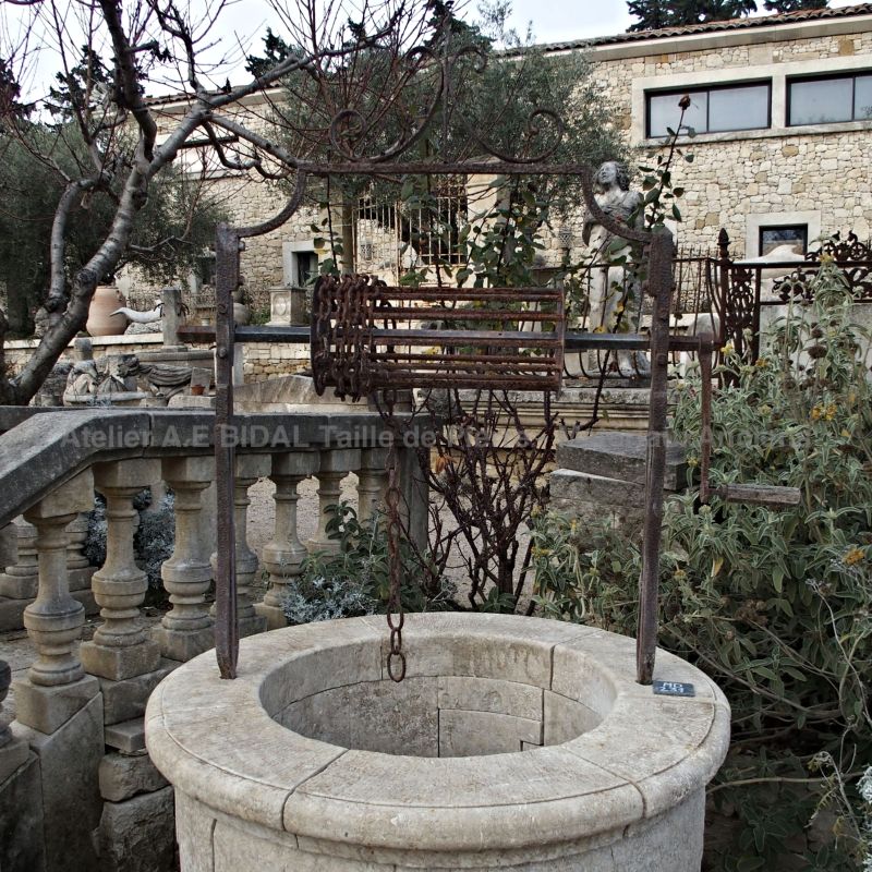 Puits en pierre avec fines margelles en pierre - taille de pierre au rendu traditionnel.