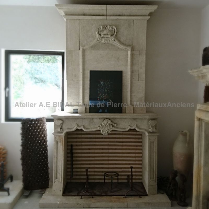 Very elegant fireplace with overmantle - a fireplace in stone of classical style by Atelier Alain BIDAL (Provence)