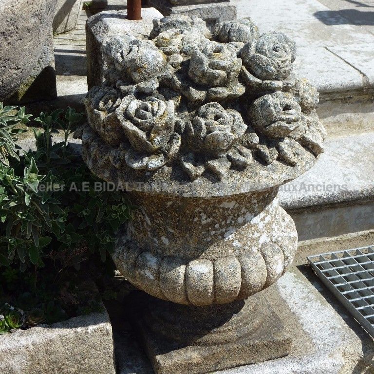 Beau vase en pierre contenant des fleurs sculptées par le sculpteur tailleur de pierre Bidal.