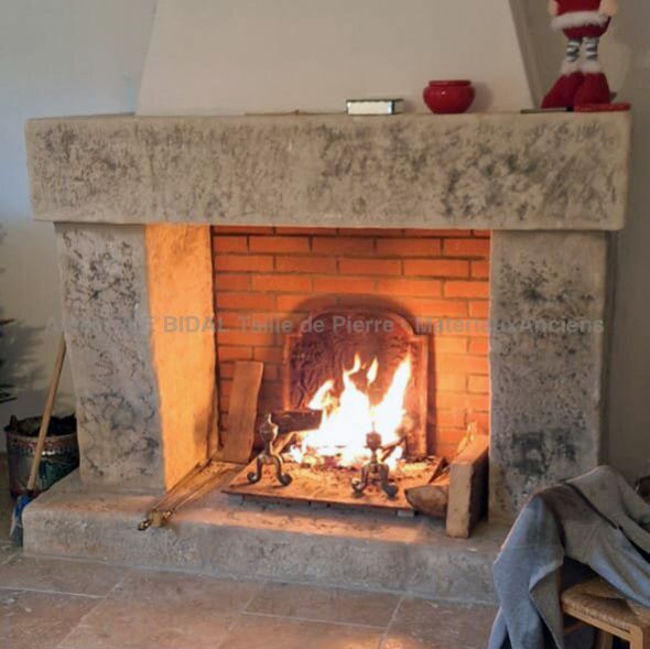 Rustic-looking mantelpiece in carved natural limestone : Atelier Alain BIDAL - Provence